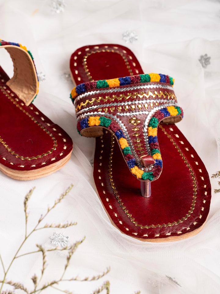 Top view of tan leather kutch stitched flats highlighting traditional craft details
