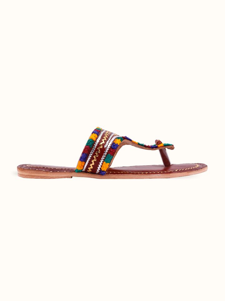 Close-up of tan leather kutch stitched flats showing intricate embroidery