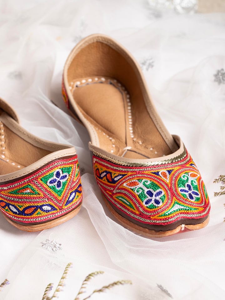 Detailed view of Tan leather haryana embroidered juttis highlighting stitching