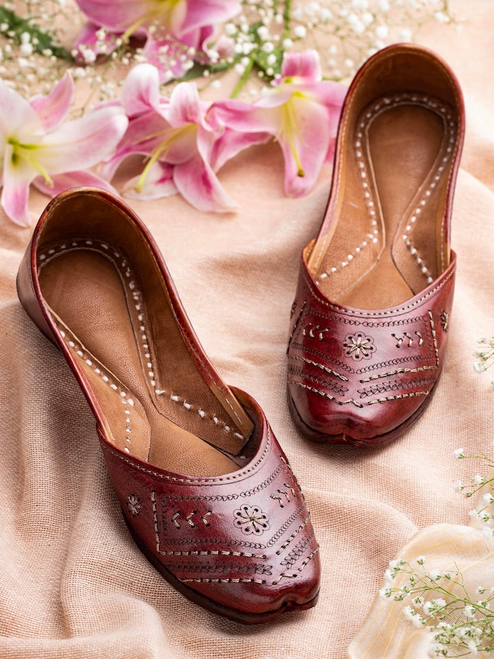 Side view of tan leather Haryana juttis highlighting the profile and stitching details