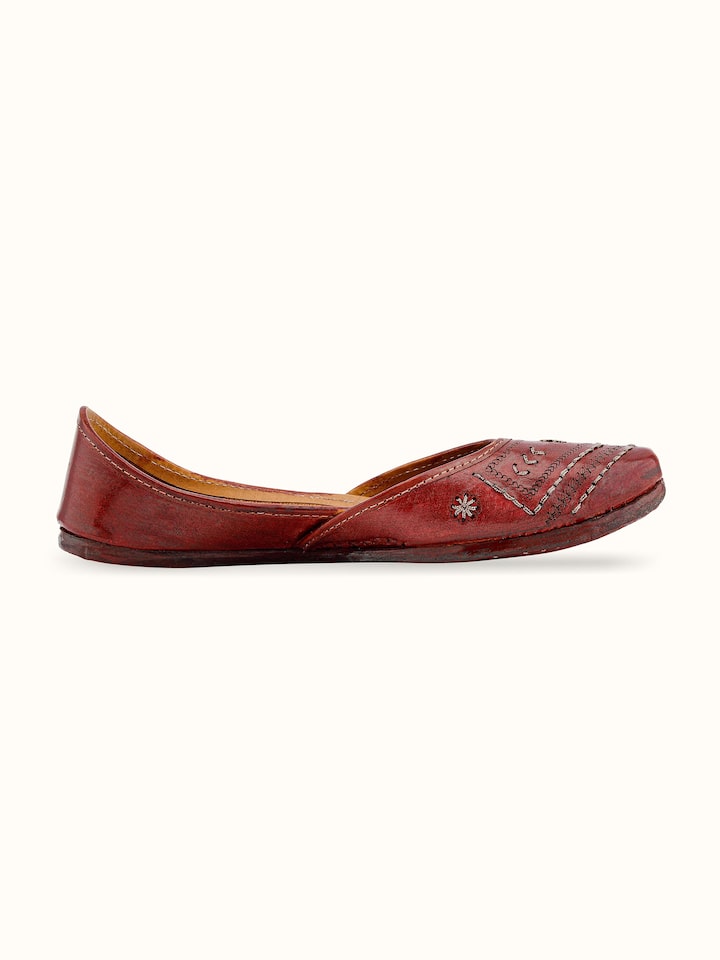 Angled view of tan leather Haryana juttis emphasizing overall design and fit