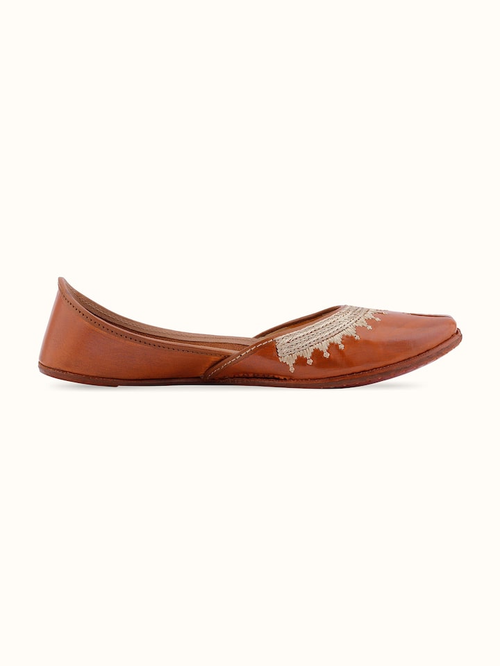 Angle view of Mustard leather haryana juttis showing design details