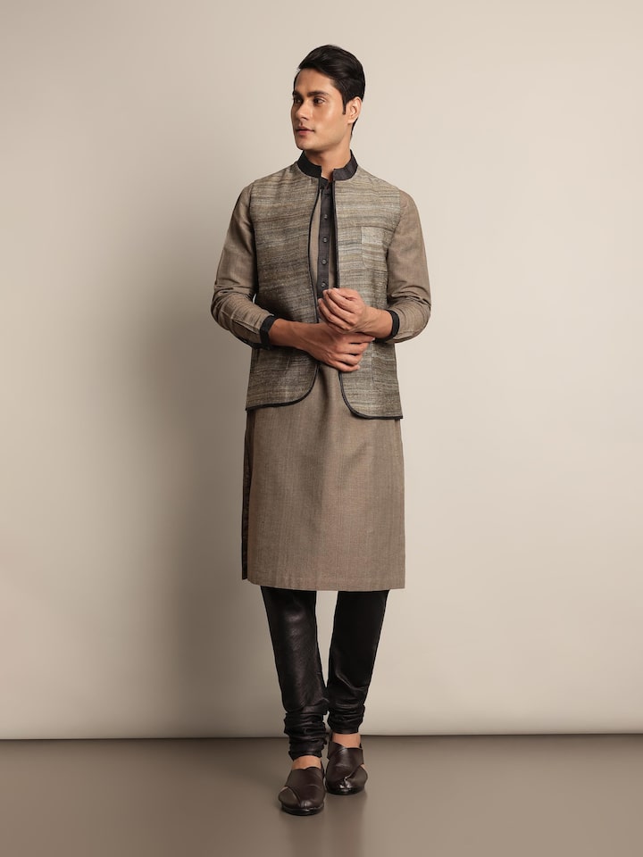 Lifestyle image of grey sleeveless jacket layered over ethnic wear for a contemporary look.