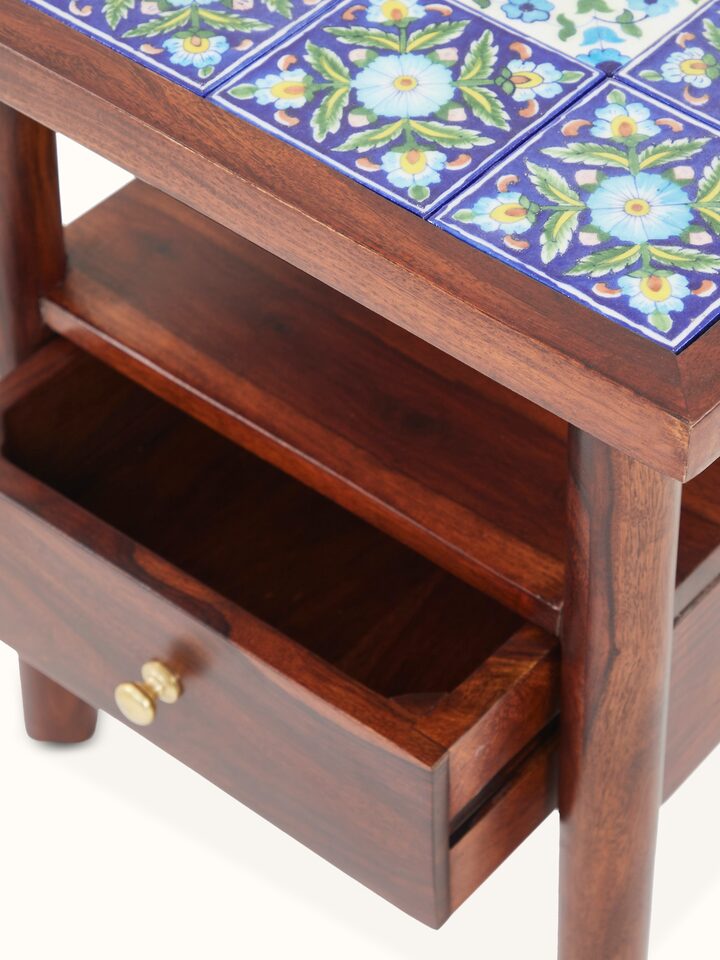 Close-up of blue pottery top on Sheesham wood side table, showcasing intricate details and vibrant colors.