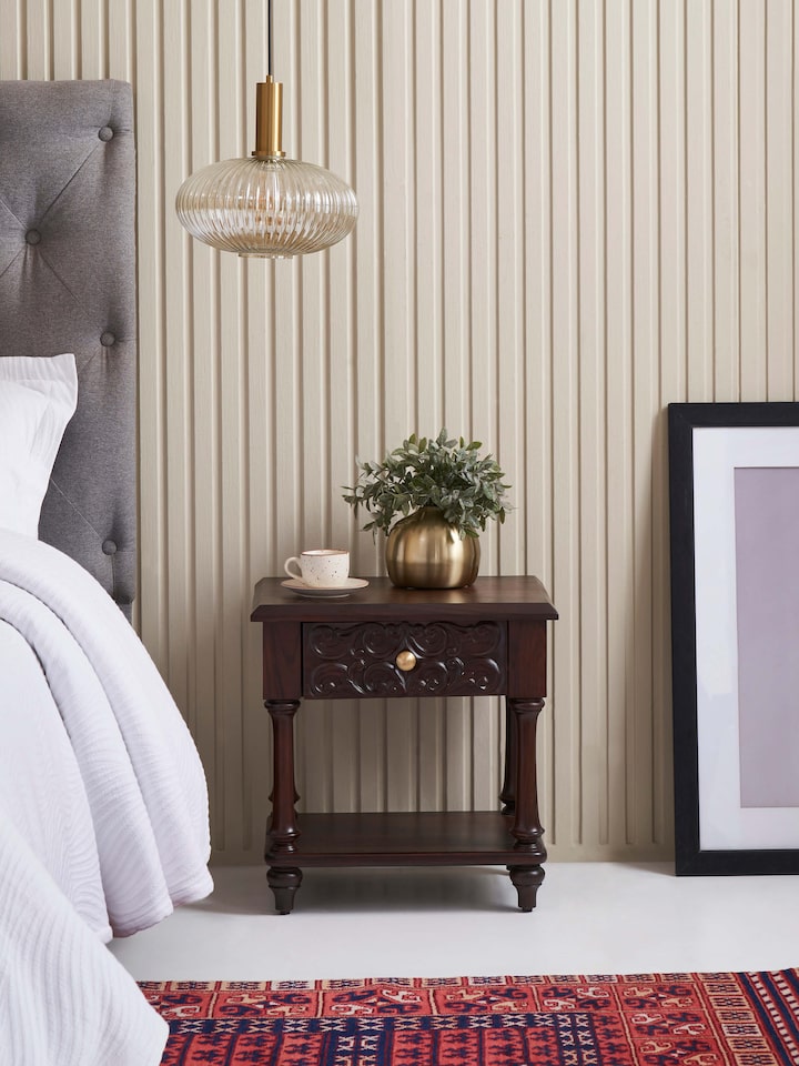 Side view highlighting the detailed carvings and the overall structure of the rosewood bedside table.