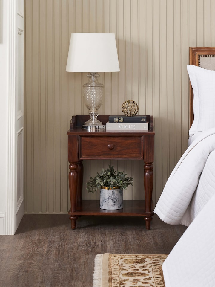 Side view of the teak finish Sheesham wood bedside table, showing its smooth surface and sleek lines.