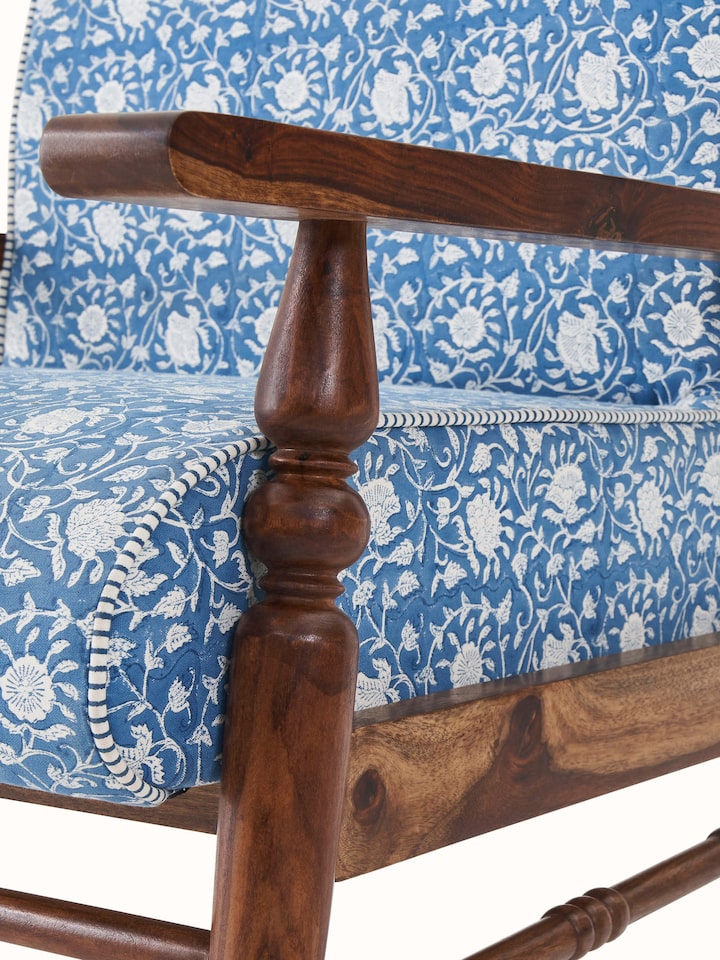 Angled view of the Sheesham wood armchair with block print upholstery, highlighting the armrests and seat design.