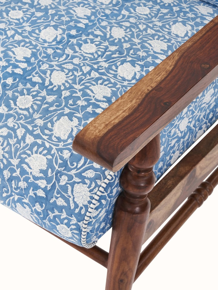 Detailed view of the Sheesham wood armchair's legs and base, showcasing its sturdy construction and elegant design.