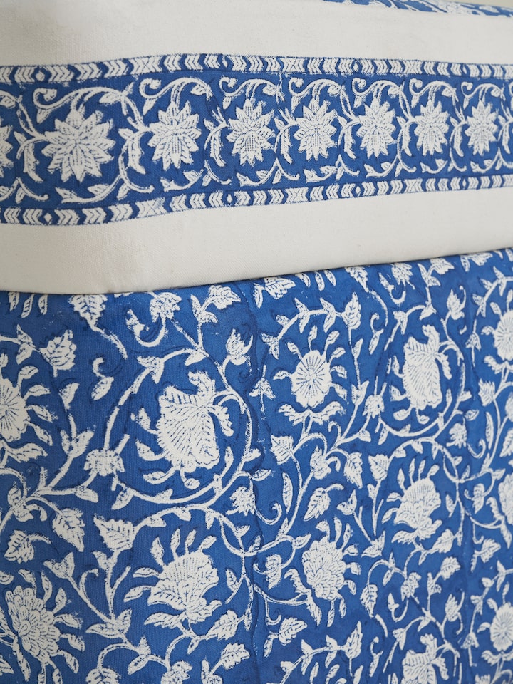 Angled view of Upholstered Sheesham Wood Sanganeri Block Print Pouffe, showing the blend of traditional block print and modern pouffe design