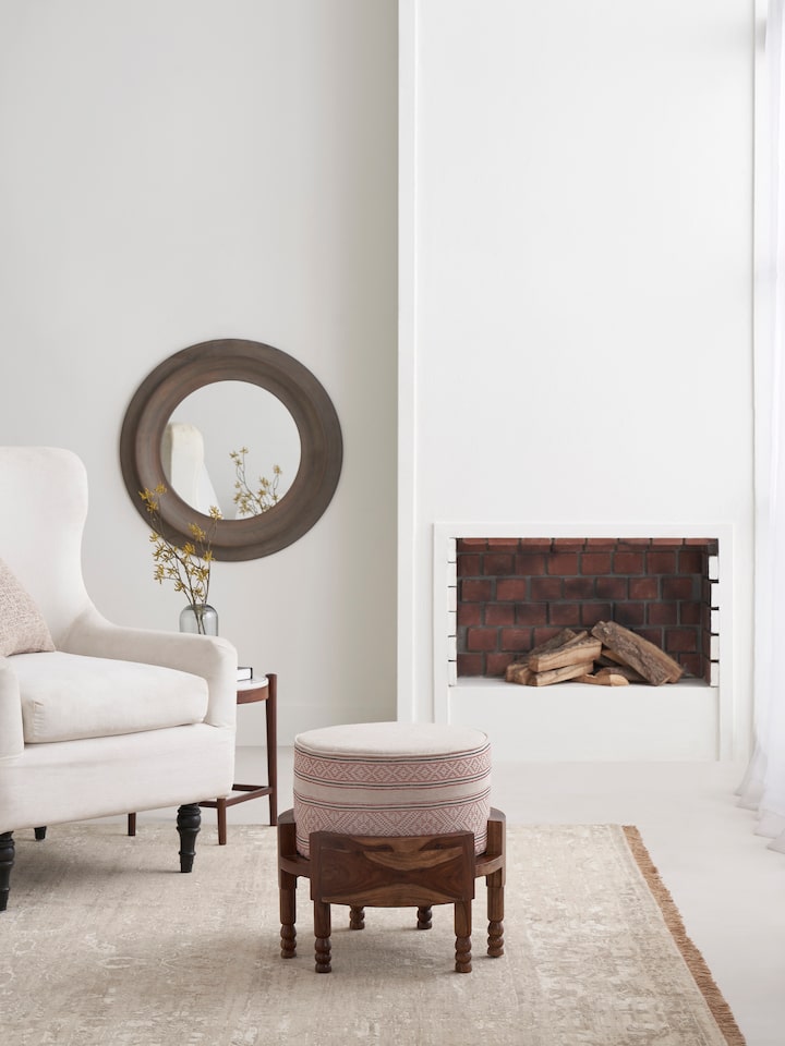 Side view of Bawan Buti upholstered Sheesham wood ottoman highlighting its shape and upholstery