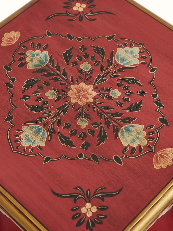 Close-up view of the mango wood end & side table, focusing on the detailed painted patterns and wood texture