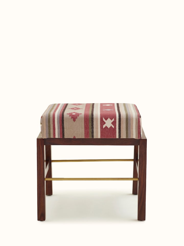 Front view of the Panja Dhurrie upholstered Sheesham wood ottoman with metal connector, showcasing its design and fabric.