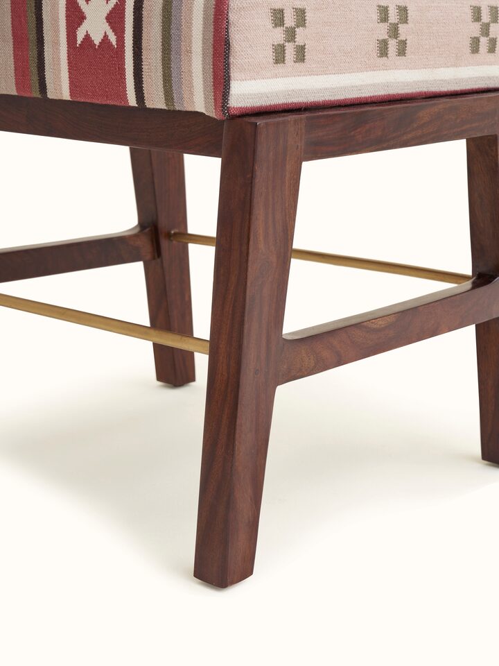 Close-up of the ottoman showing the Panja Dhurrie fabric upholstery and metal connector detail.
