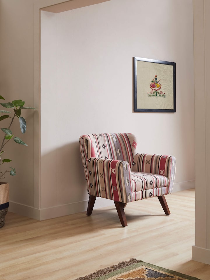 Side view of Panja Dhurrie upholstered Sheesham wood wing chair, highlighting the elegant winged back and rich wood finish