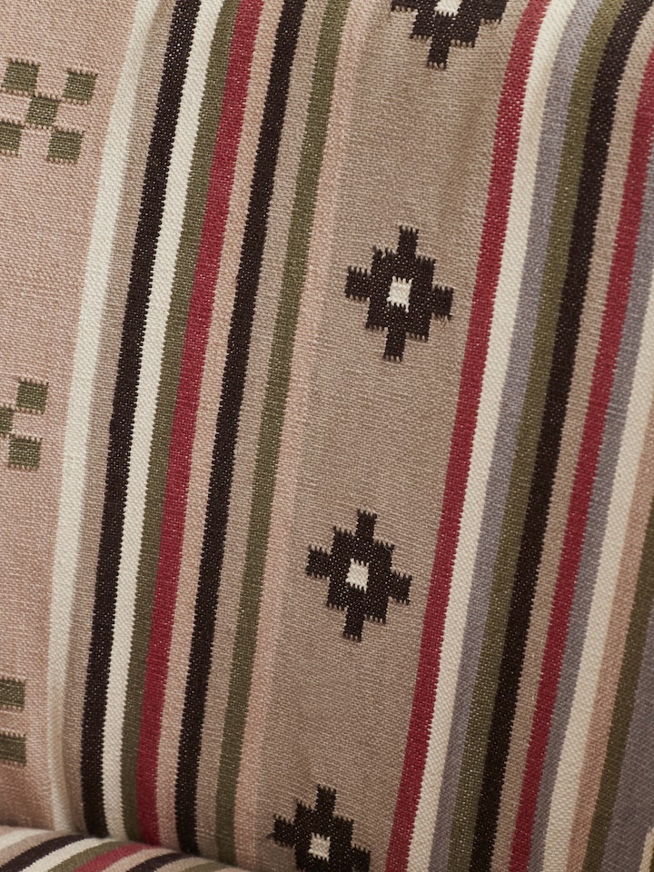 Close-up of the armrest and upholstery of Panja Dhurrie upholstered Sheesham wood wing chair, emphasizing the detailed stitching