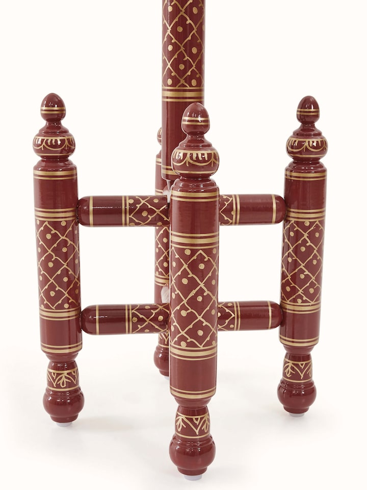 Side view of teak wood Sankheda maroon coat hanger, emphasizing the smooth finish and ornate design.