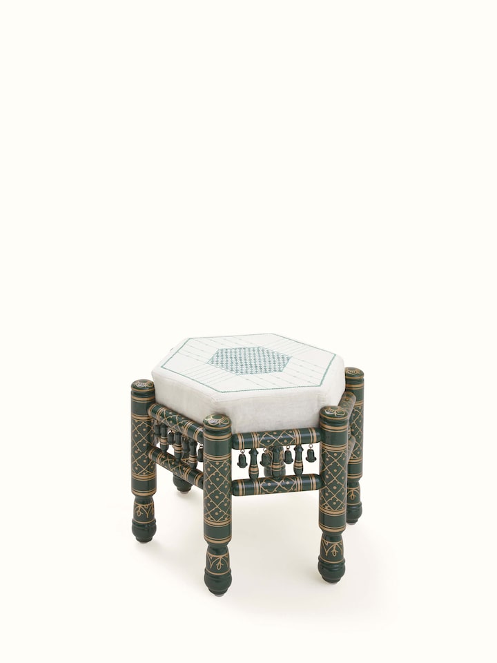 Angled view of Upholstered teak wood Sankheda octagonal pouffe showing intricate craftsmanship