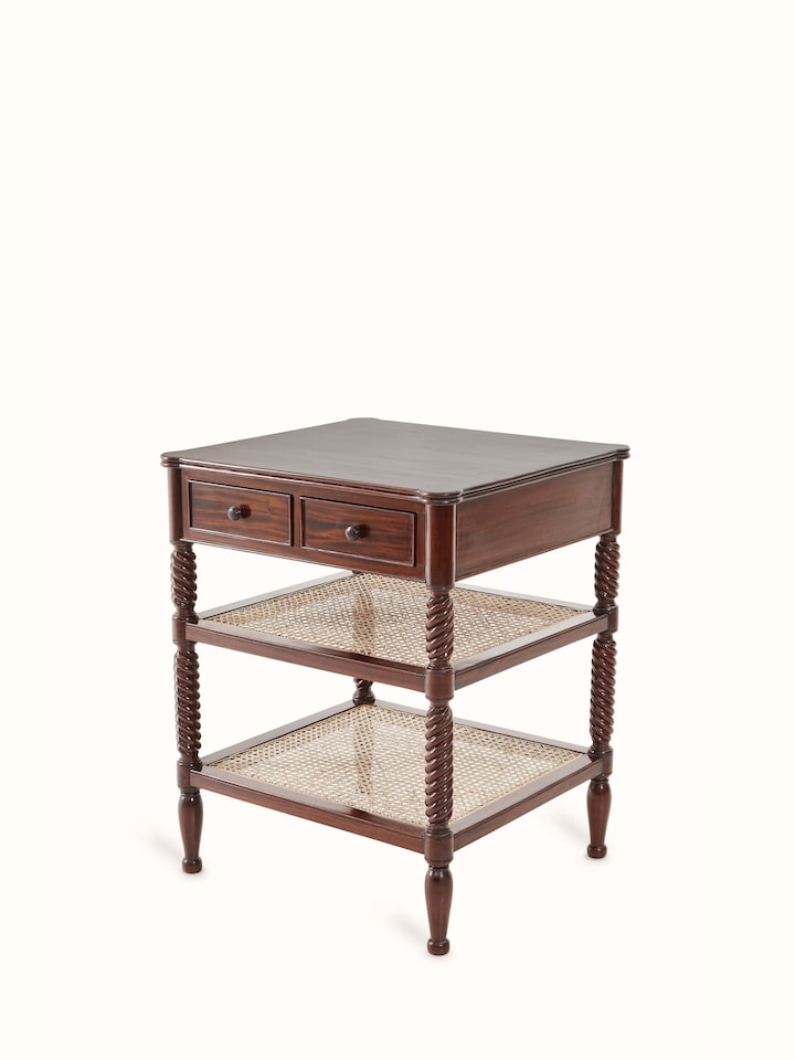 Close-up of the mahogany wood and cane bedside table, showing the intricate cane detailing and polished wood surface.