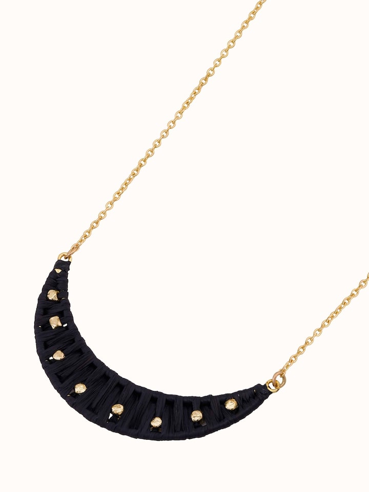 Raffia fibre long necklace displayed on a flat surface emphasizing its elegant design and natural texture.