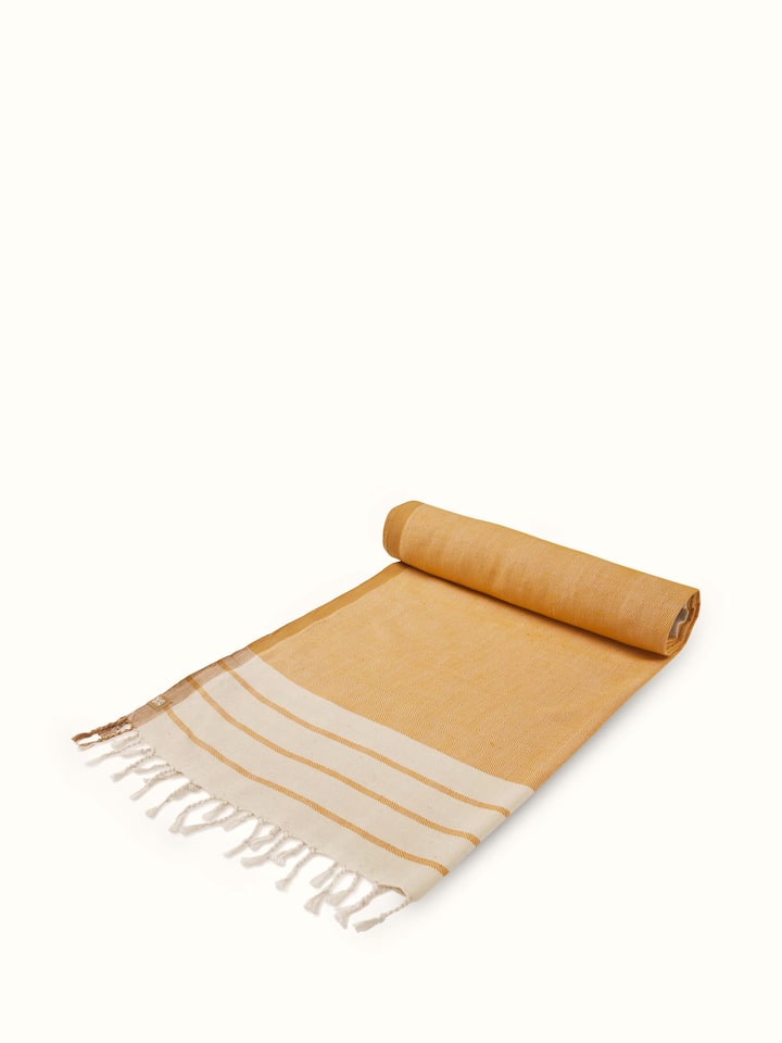 Side view of a large yellow striped cotton bath towel, capturing its vibrant color and luxurious feel.