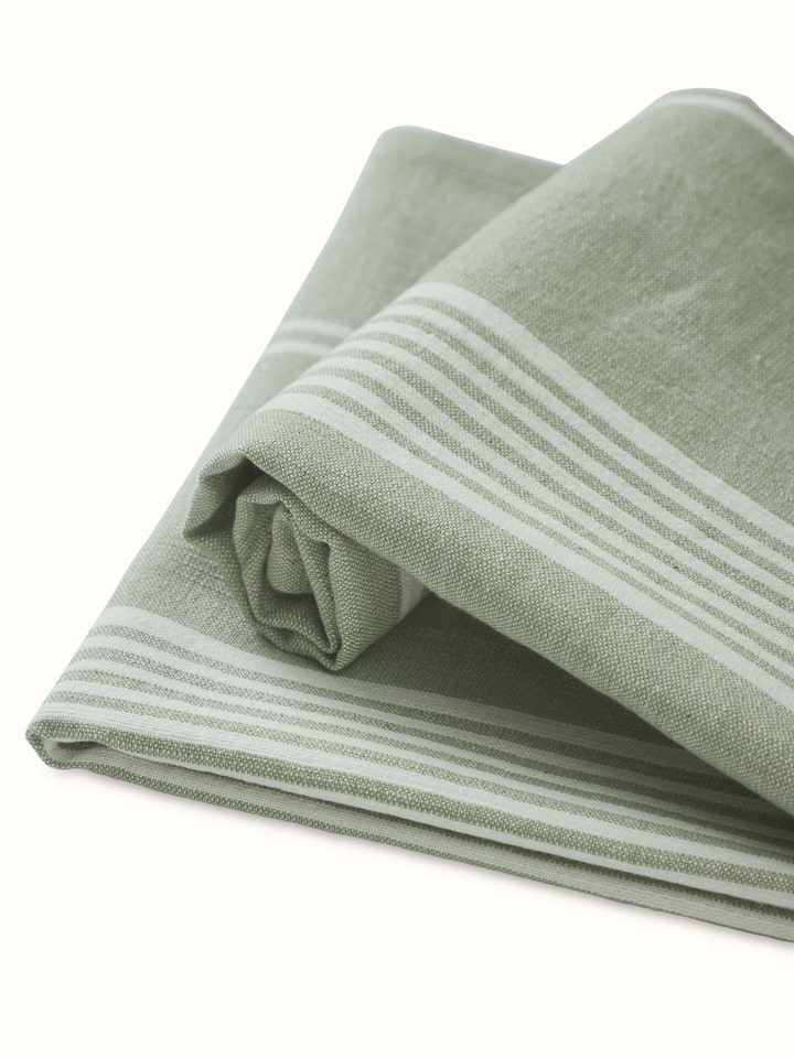 Simhi green stripe cotton hand towels displayed in a bathroom setting, showcasing their practical use and design.