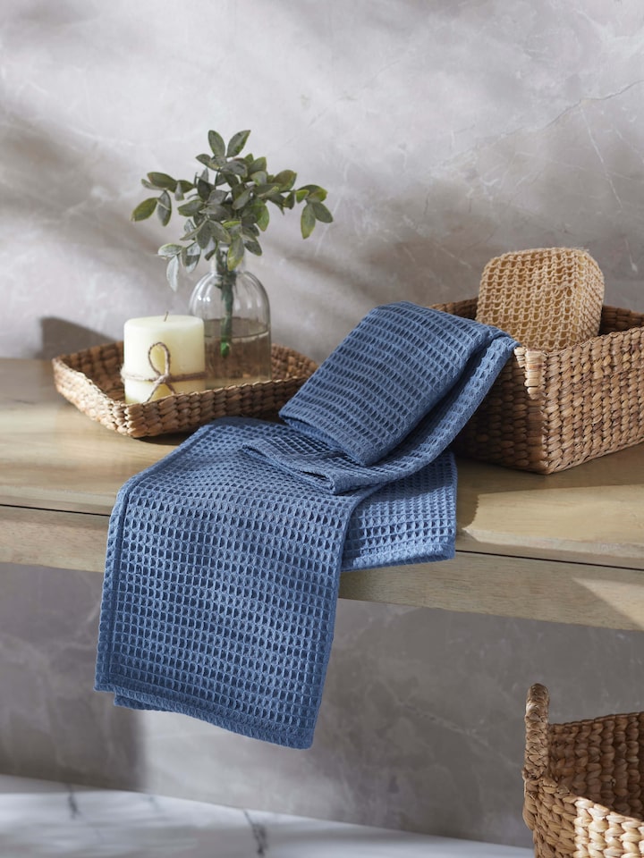 Close-up of Amala blue solid cotton hand towels, focusing on the waffle texture and the vibrant blue hue.