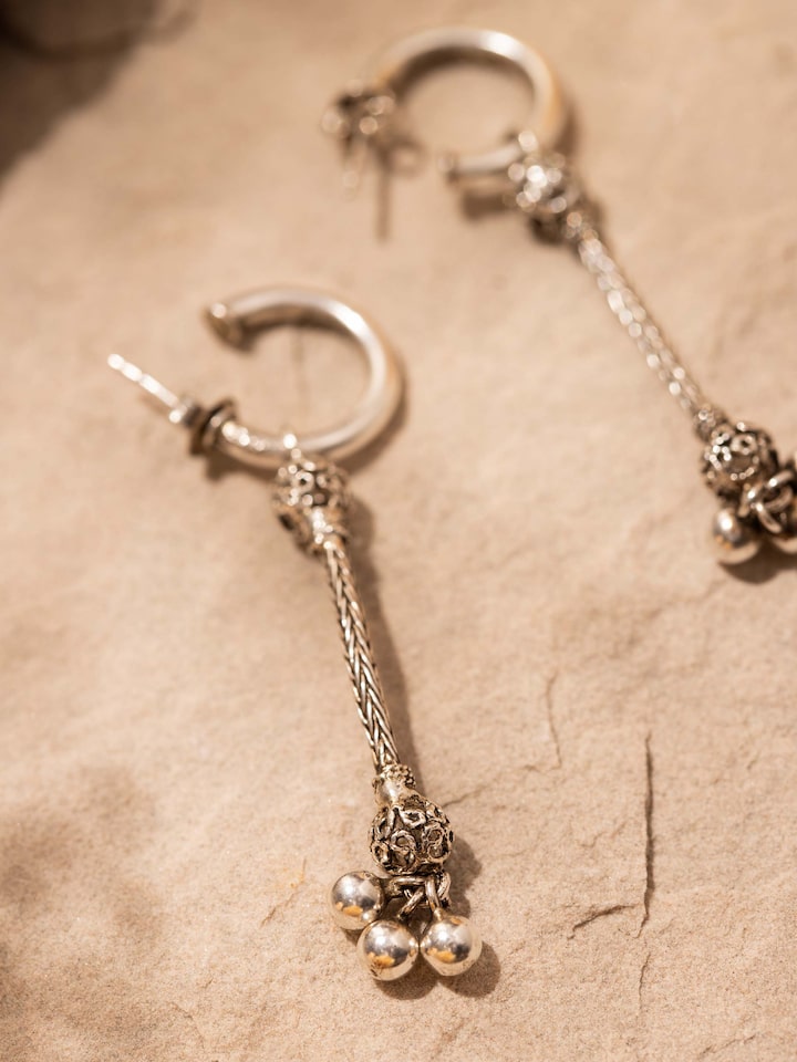 Angled view of Silver Drop Earrings emphasizing the earring's elegant design and reflective surface