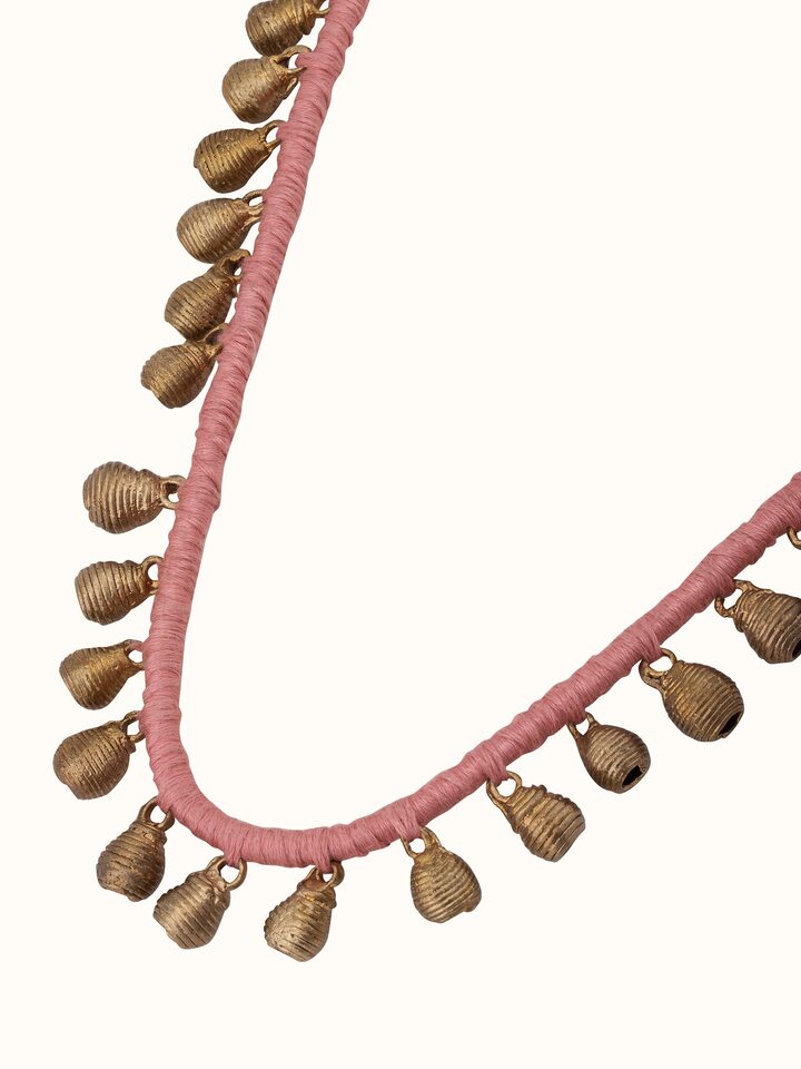 Dhokra long necklace displayed on a flat surface highlighting its elegant design and traditional craftsmanship.