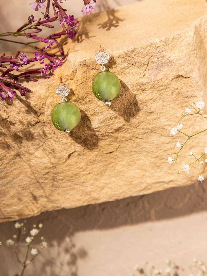 Styled detail view of Silver Flame Glass Drop Earrings worn on the ear, shown in another styled shot