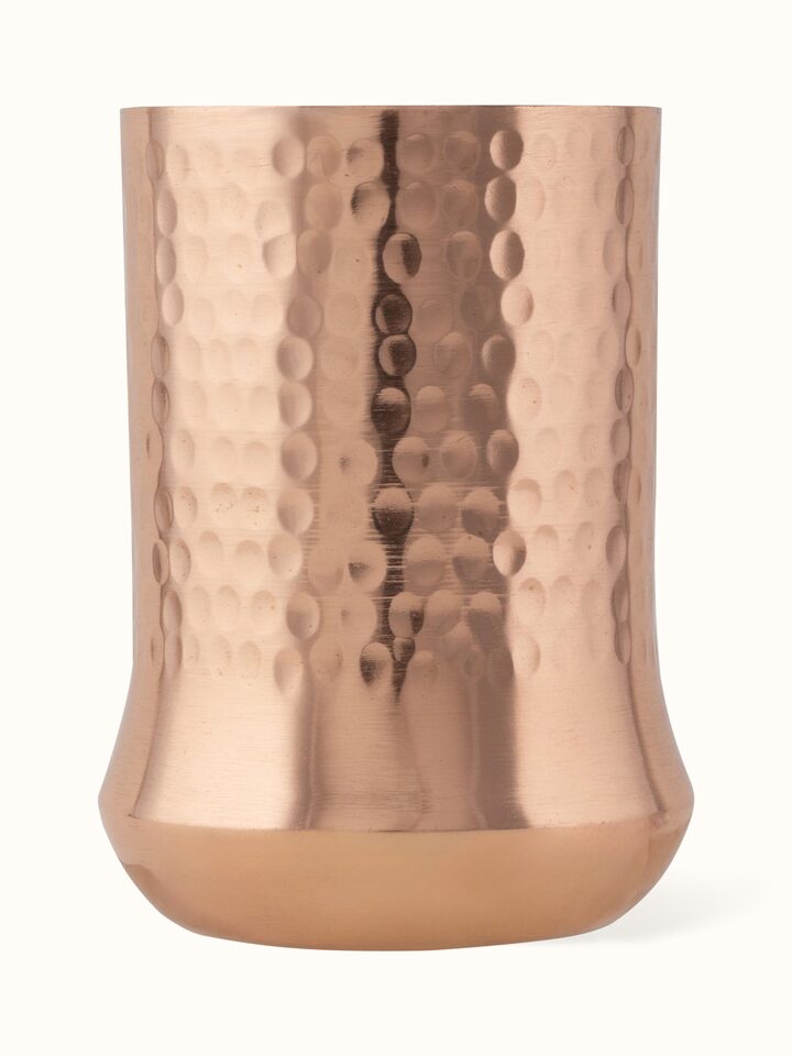 Angled view of copper metal glass emphasizing its elegant shape and design.