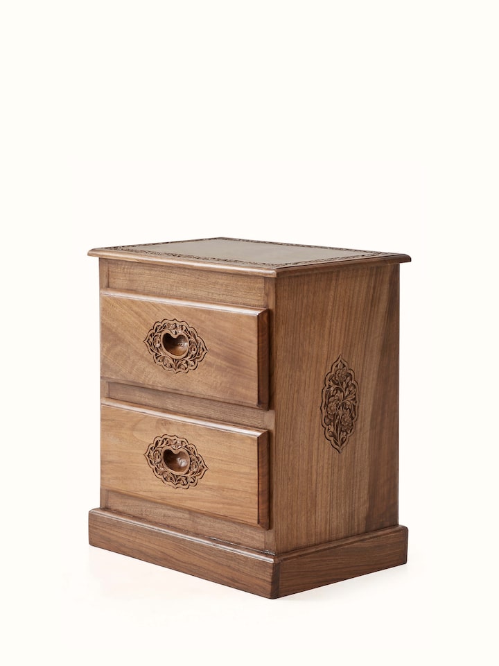 Close-up of the carved details on the walnut wood bedside table, emphasizing the intricate patterns and textures