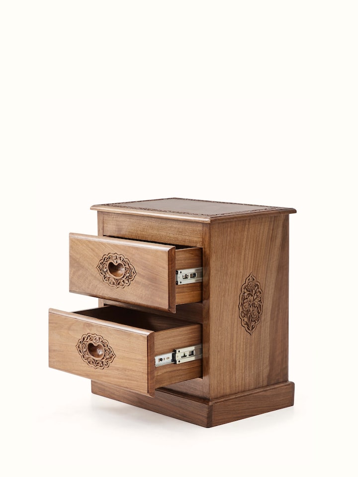 Close-up view of the walnut wood finish and carving on the bedside table, emphasizing the intricate details and craftsmanship