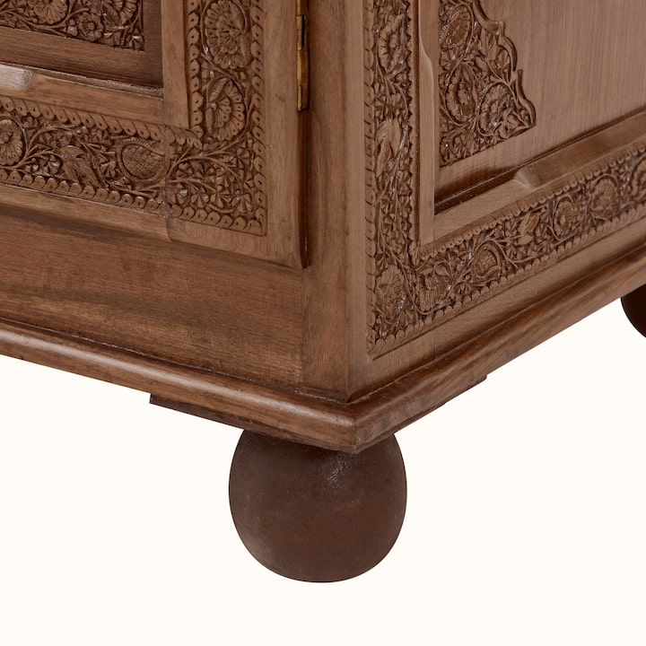 Angled view of the walnut sideboard, showcasing its five drawers and the elegant design of the carved wood.