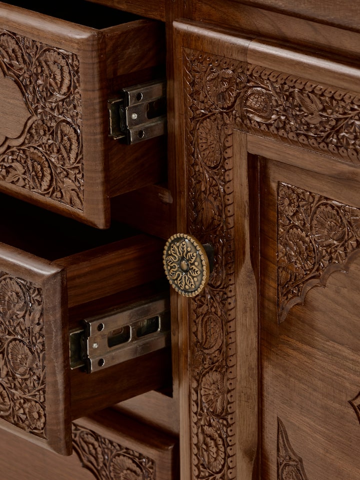 View of the walnut wood sideboard showing the carved patterns and overall structure of the piece.