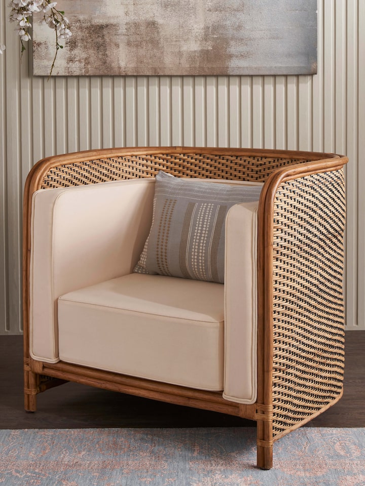 Side view of Upholstered Cane Armchair showcasing its armrest and cane weaving