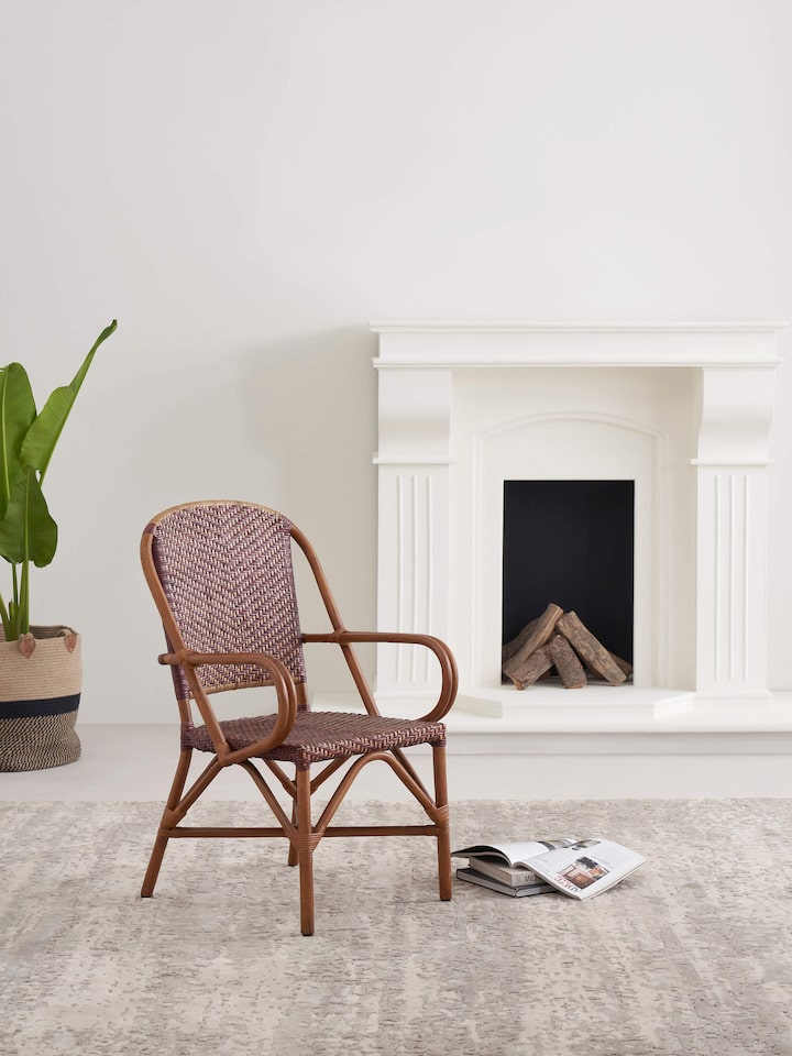 Side view of the cane patio chair, highlighting the intricate cane weaving and sturdy frame