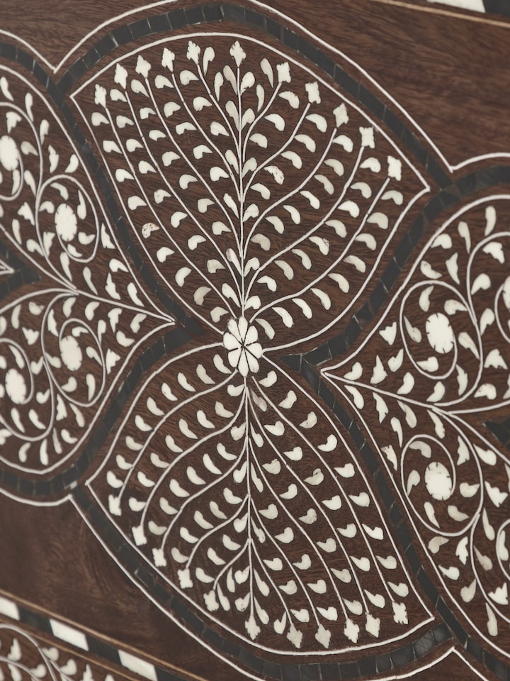 Close-up of the turned legs of the Sheesham wood trunk, showing the detailed woodwork and elegant finish