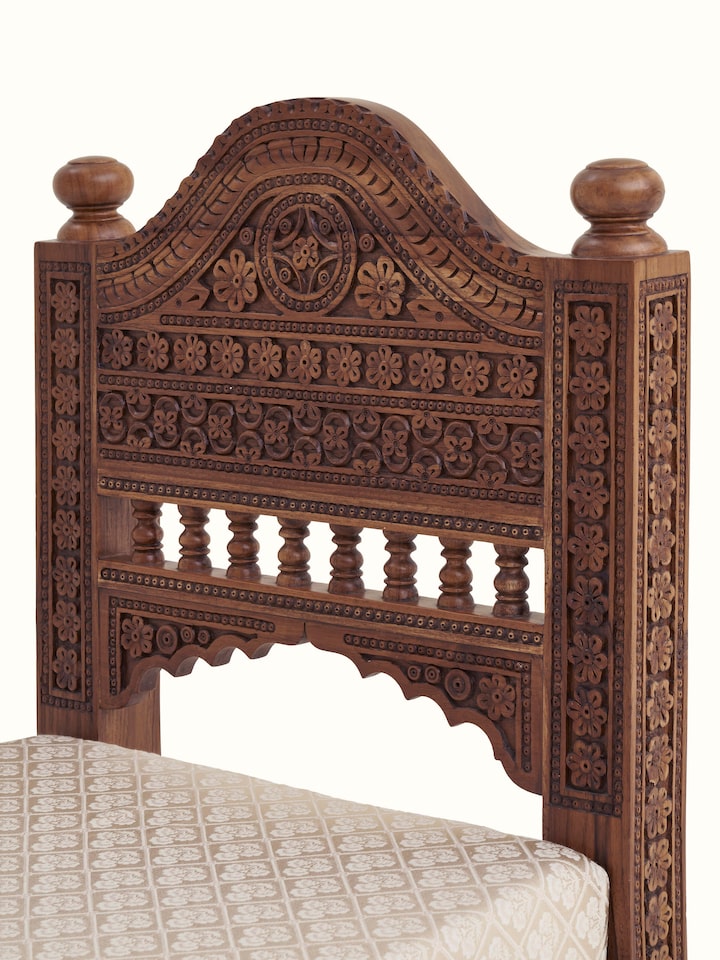 Side view of Carved Sheesham wood upholstered sofa highlighting the detailed carvings and side upholstery