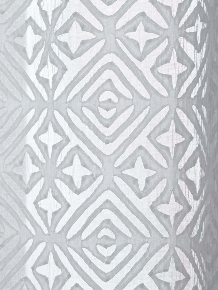 Mandana White Trellis sheer curtain hanging in a room, showcasing its elegant and airy design