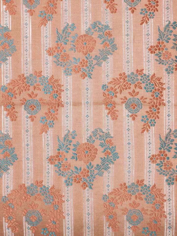 Close-up of rich brocade weave and golden motifs on peach silk Banarasi cushion cover