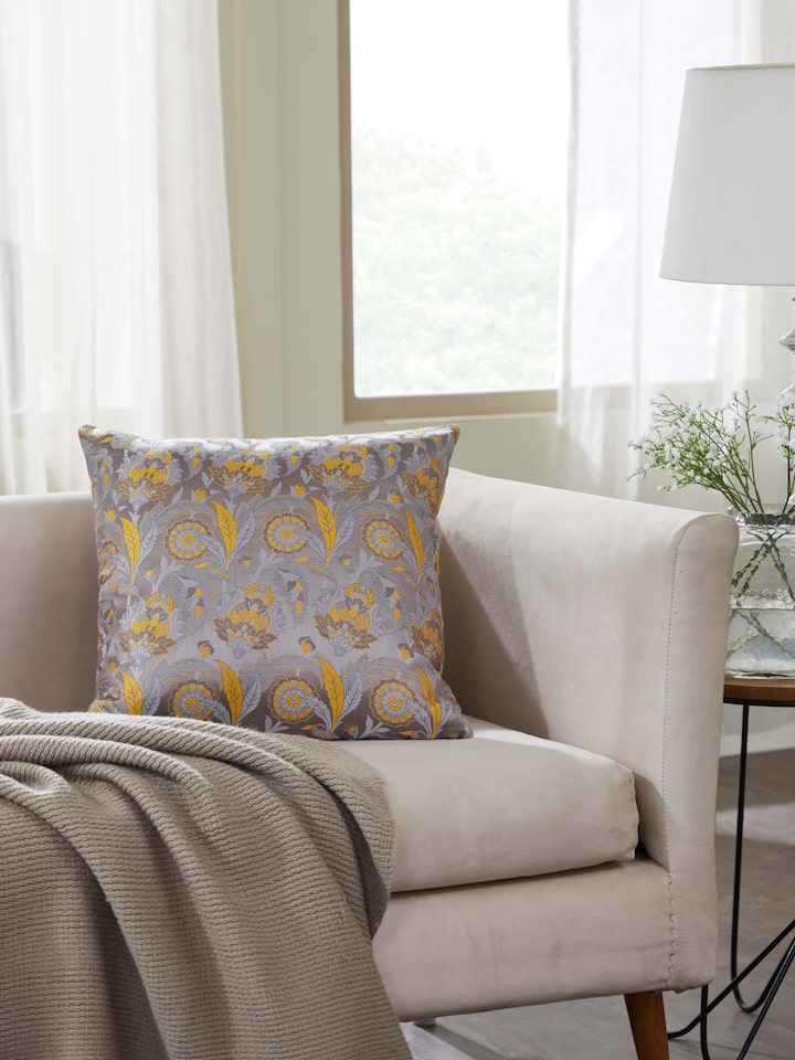 Lifestyle image of grey silk Banarasi cushion cover on a sofa setup