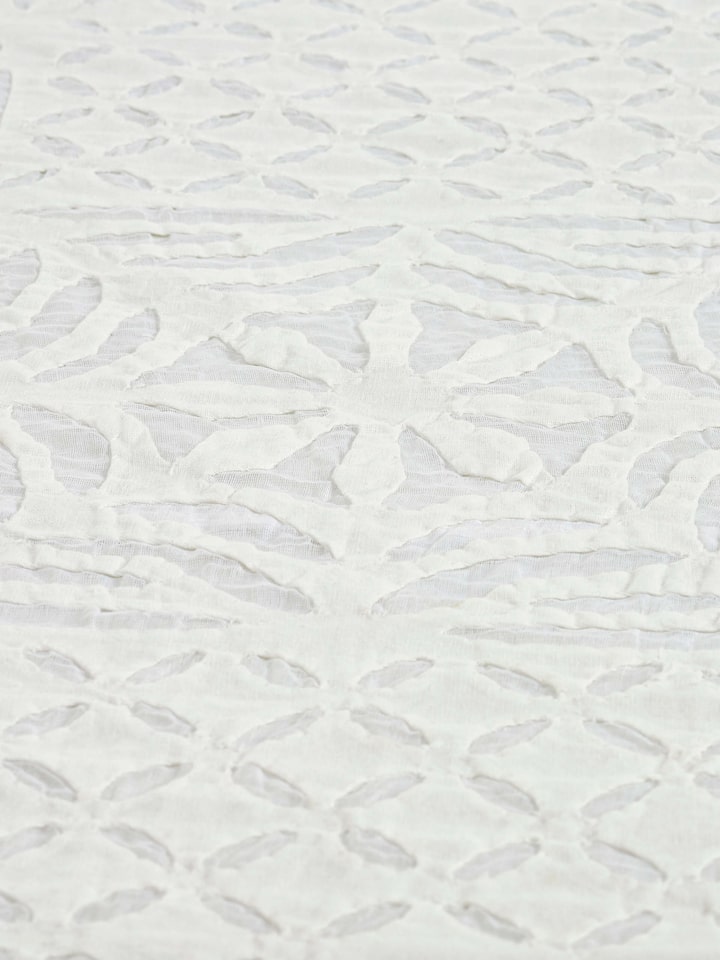 Close-up of Ekam white trellis cotton appliqué embroidered table cover (4 seater) with focus on the detailed appliqué work.
