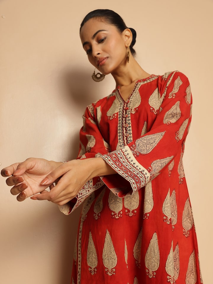 Angled lifestyle view showing traditional motifs and curved hem.