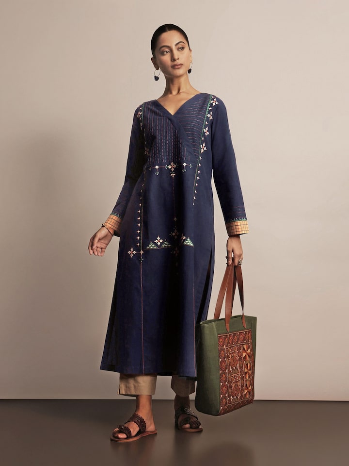 Model in blue embroidered kurta styled with ethnic silver earrings and churidar.
