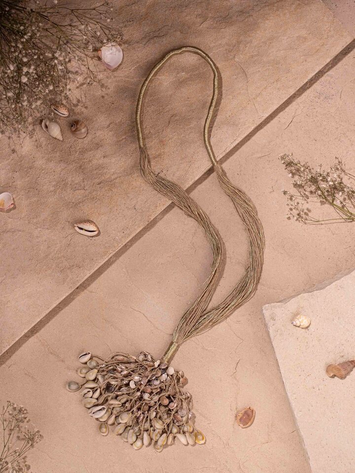 "Close-up of cowrie shell long necklace with focus on shell arrangement"