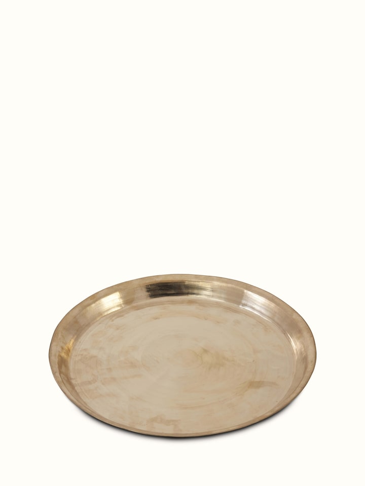 Angled view of bell metal Balisiri dinner plate highlighting detailed engravings and stylish design