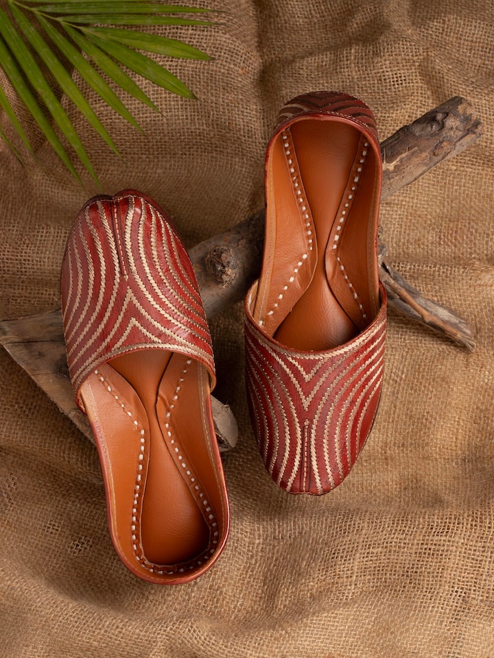 Side view of brown leather embroidered punjabi juttis highlighting detailed craftsmanship