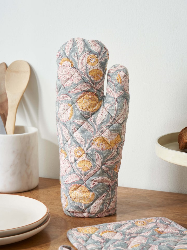 Lifestyle image of Samaha Grey Floral Cotton Sanganeri Block Printed Oven Mitts in use, highlighting their floral design.