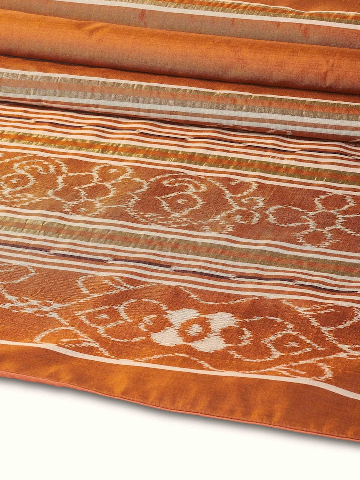 Folded silk bed runner showing thickness and artisanal detail.