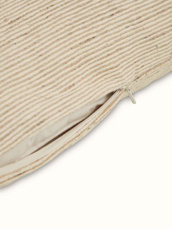 Side angle showing sheen and handwoven texture of brown silk cushion